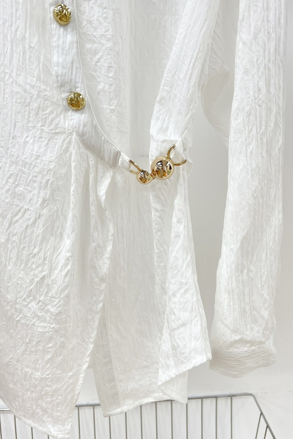 Blusa Blanca Asimétrica con Botones Dorados y Nudo Lateral