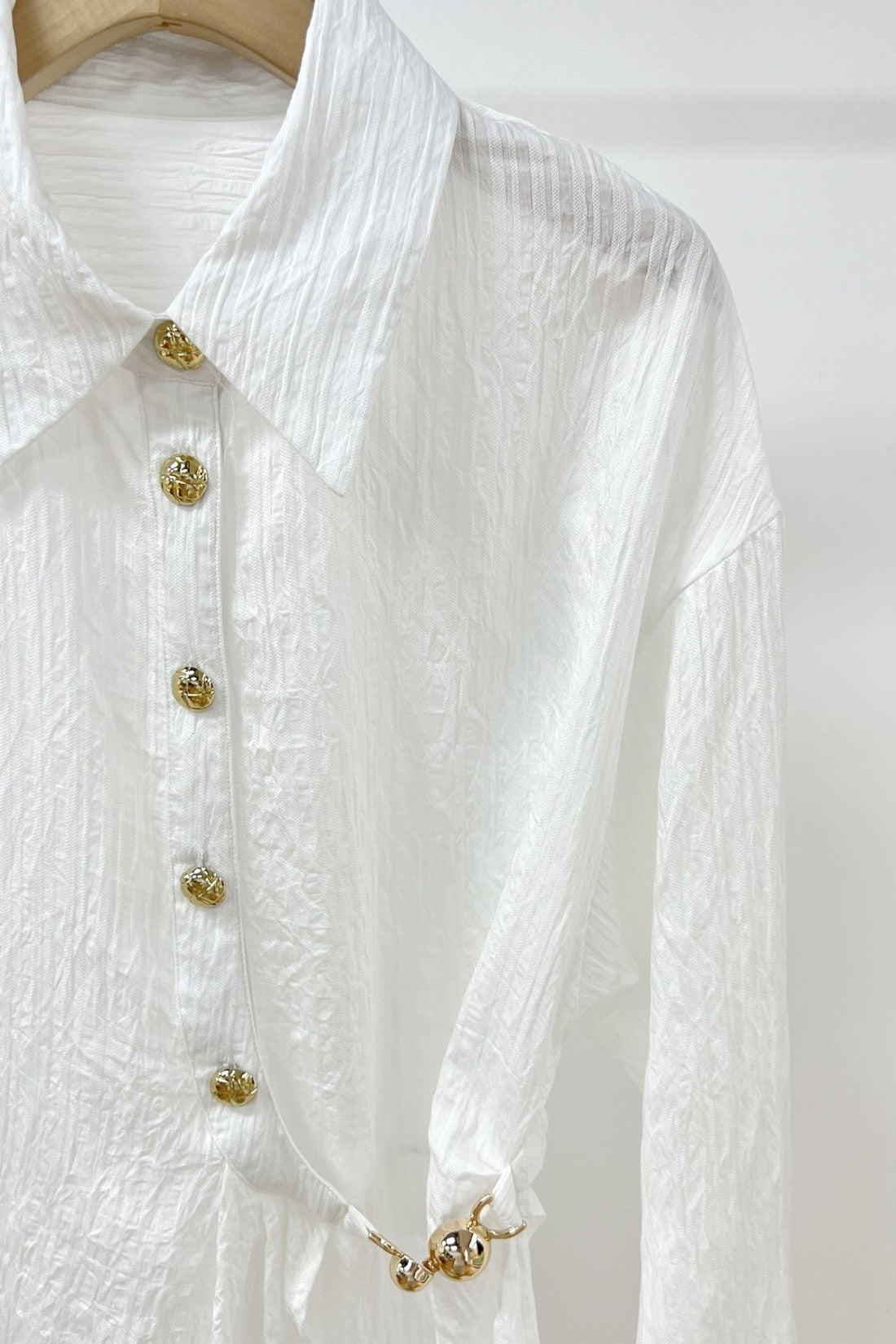 Blusa Blanca Asimétrica con Botones Dorados y Nudo Lateral